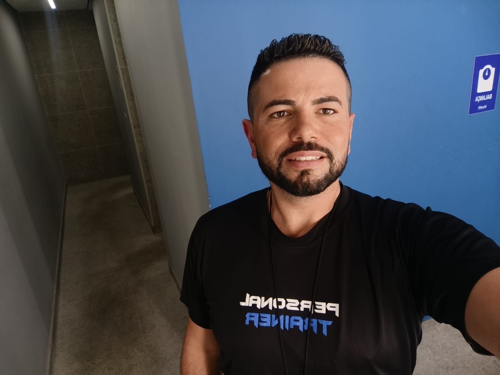 Personal trainer Henrique Munhoz em uma academia, com camiseta de personal trainer